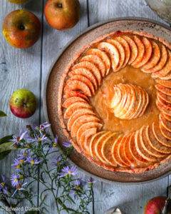 Apricot glaze jewel-like concentric apple slices with macerated apple puree over a pillowy amaranth pastry; Apple Tart. Edward Daniel ©.