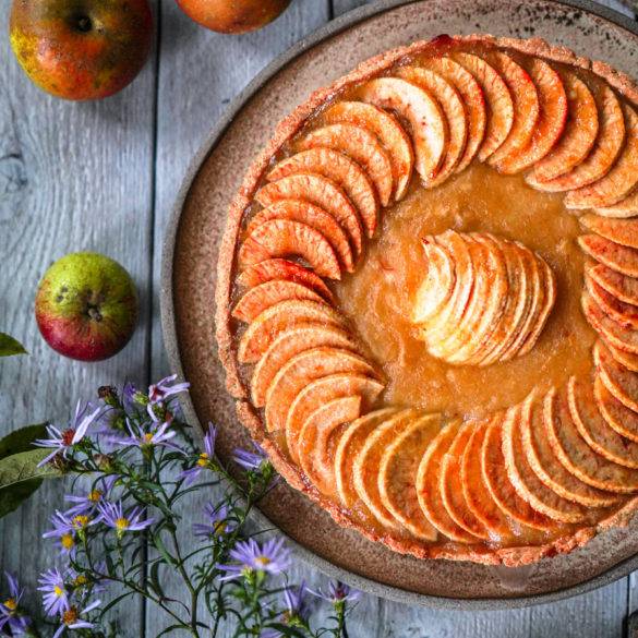 Apricot glaze jewel-like concentric apple slices with macerated apple puree over a pillowy amaranth pastry; Apple Tart. Edward Daniel ©.