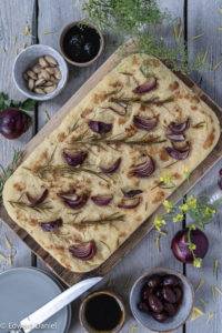 Aromatic mint-pine-like Rosemary scented and fleshy Red Onion scattered over an Italian olive oil pillowy Focaccia bread.