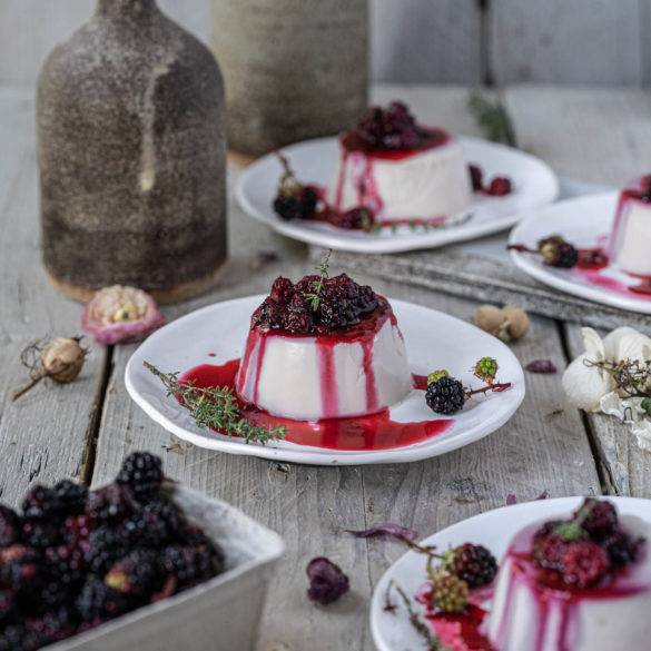 Ripe burst berry coulis on a bed of creamy coconut panna cotta with a hint of floral vanilla and minty thyme; Blackberry Panna Cotta.