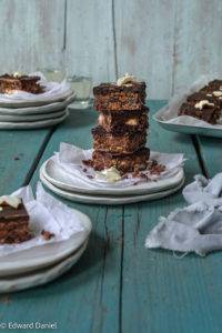Bite-sized firm almond rice-based biscuit with coconut raisin, topped will a layer of dark chocolate; Coconut Chocolate Tiffin. Edward Daniel ©.