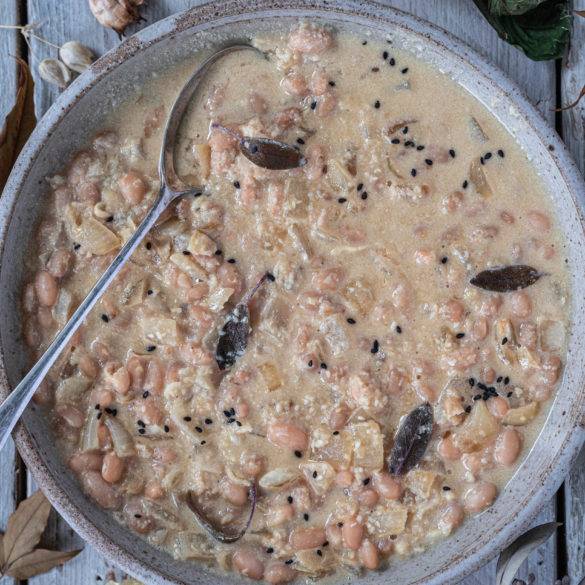 Hearty Tuscan beans stewed in wine and almond cream with a hint of sage topped off with sesame seeds and nutritional yeast; Tuscan Bean Stew.