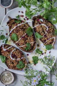 Aubergine boats coated with buckwheat groats with balsamic vinegar and garnished rose petals; Baked Aubergine stuffed with Buckwheat.