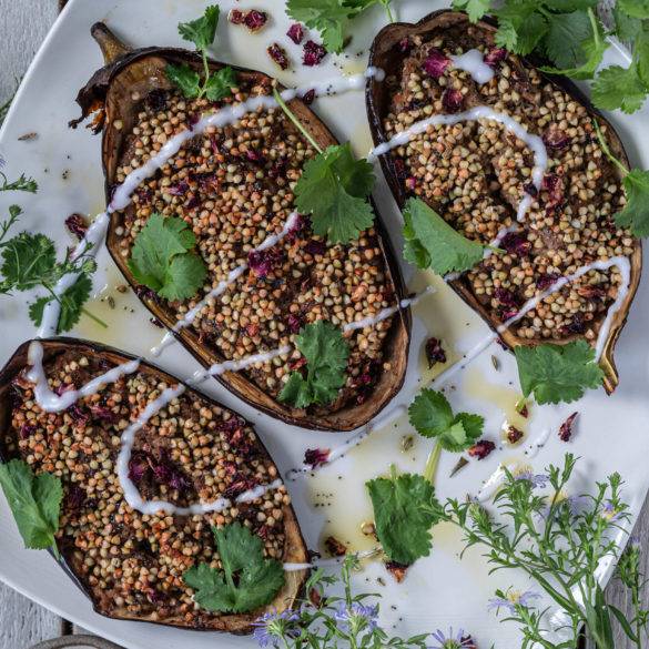 Aubergine boats coated with buckwheat groats with balsamic vinegar and garnished rose petals; Baked Aubergine stuffed with Buckwheat.