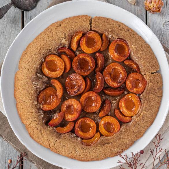 Caramelised sugar basted over tart juicy apricots over a pillowy cream oat and nutty millet pastry; Vegan gluten-free Apricot Tarte Tatin recipe. Edward Daniel ©.