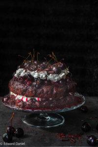 Spongy sandwiched chocolate cake with a burst cherry sauce topped with fluffy silky oat cream and chocolate shavings; Black Forest Gateau. Edward Daniel ©.